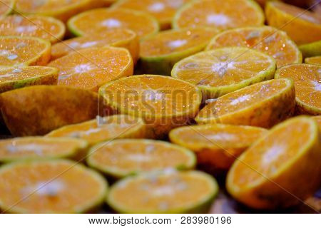 In Selective Focus A Pile Of Fresh Oranges Cut In A Half