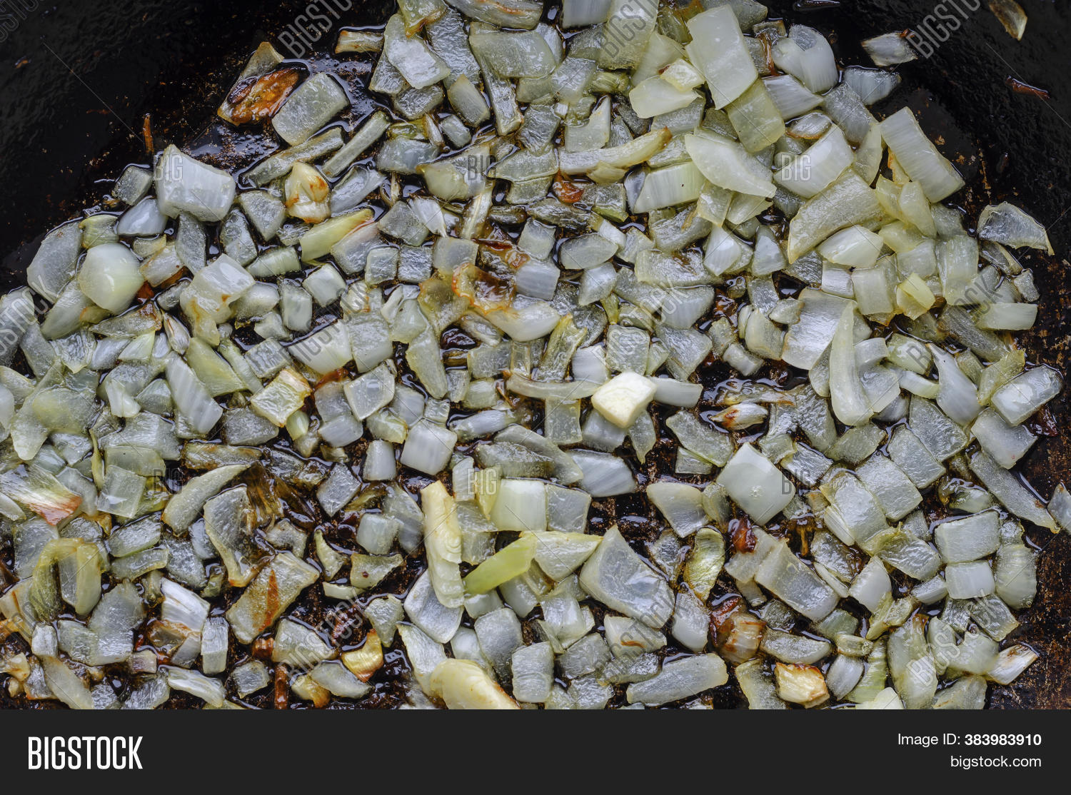 Aromatic onions and spices being sautéed in a pan