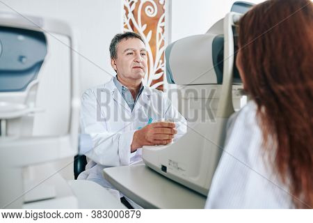 Opthalmologist Using A Non-mydriatic Retinal Camera When Checking Astigmatism Of Young Woman