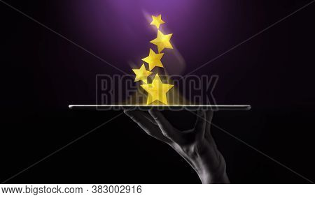Success In Business Or Personal Talent Concept. Hand Raise Up A Digital Tablet With Golden Five Star