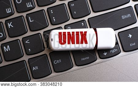 Unix - The Word On A White Flash Drive, Lying On A Black Laptop Keyboard. Computers Concept
