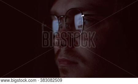 Close Up Of Nerd Face Reading Data Reflected In Glasses, Working Late. Concept. Clever Nformation An