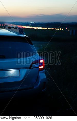 Car Taillights At Night Time. City Lights On Background