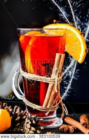 Mulled Wine Hot Christmas Drink With On A Dark Background. Orange Slices, Cinnamon Sticks, Christmas
