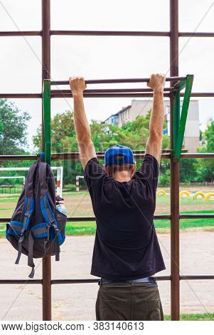 Athlete Doing Pull-up On Horizontal Bar. Male Sportsman Doing Fitness Exercises On Playground Outdoo