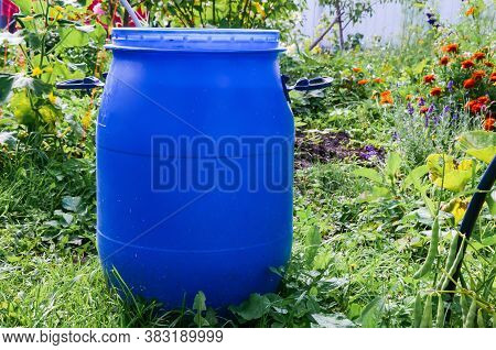 Large Blue Plastic Garden Barrel With Handles Outdoors In The Garden. Rainwater Tank In The Garden O