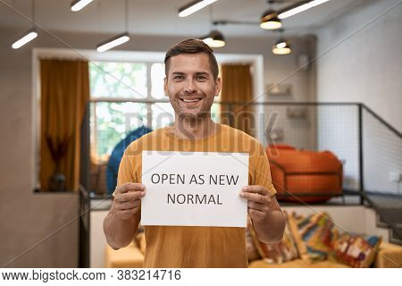 We Are Open. Young Happy Man, Office Worker Showing Paper With Text Open As New Normal And Smiling A