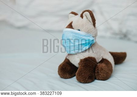 Cat Siamese With Medical Masks On Bed. Sicker Disease In Children. Coronovirus, Quarantine, Epidemic