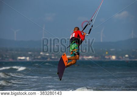 Kitesurfing on the waves of the sea in Mui Ne beach, Phan Thiet, Binh Thuan, Vietnam. Kitesurfing, Kiteboarding action photos. Kitesurf In Action against airheads