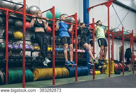 Group Of Athletes Doing Pull Ups In The Gym