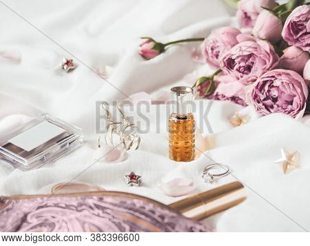 Cosmetic Bag On Crumpled White Fabric Background. Decorative Cosmetic - Perfume, Mascara, Eye And Br