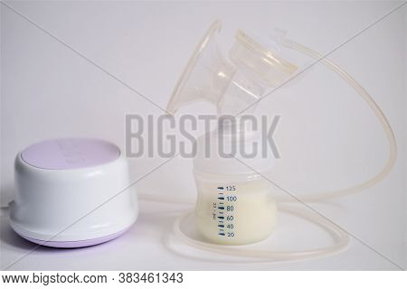 The Electric Breast Pump Is On The Table In The Kitchen. Breast Pump With Milk. Give Expressed Breas
