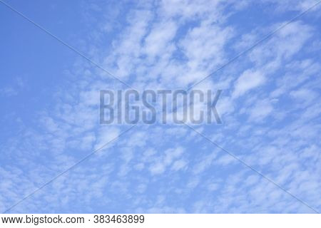 Upward View Of Beautiful White Fluffy Clouds On Vivid Blue Sky