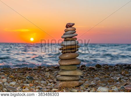 Pyramid Of Stones On Pebble Beach At Sunset