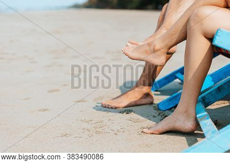 Couple Sitting On The Deck Chairs At The Beach. Honymoon, Love, Travel Or Vacation Concept.