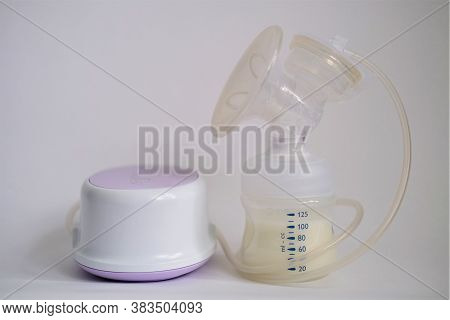 The Electric Breast Pump Is On The Table In The Kitchen. Breast Pump With Milk. Give Expressed Breas