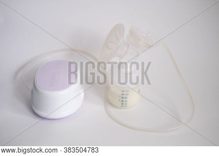 The Electric Breast Pump Is On The Table In The Kitchen. Breast Pump With Milk. Give Expressed Breas
