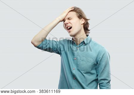He Lost Everything. Portrait Of Sad Handsome Long Haired Blonde Young Man In Blue Casual Shirt Stand
