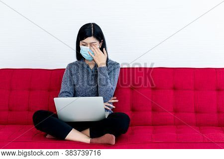 Portrait Images Of Asian Attractive Woman Wearing A Surgical Mask Sitting On The Red Sofa, She Has E