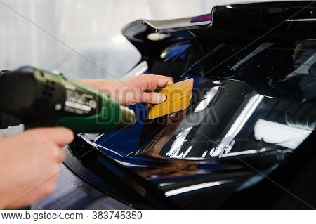Car Tinting. Worker Applying Tinting Foil On Car Window
