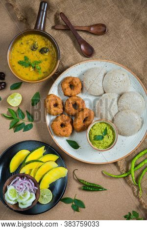 Top View Of Idli, Wada, Sambar And Chutney. Traditional South Indian Food, Surrounded With Lemon, Ra