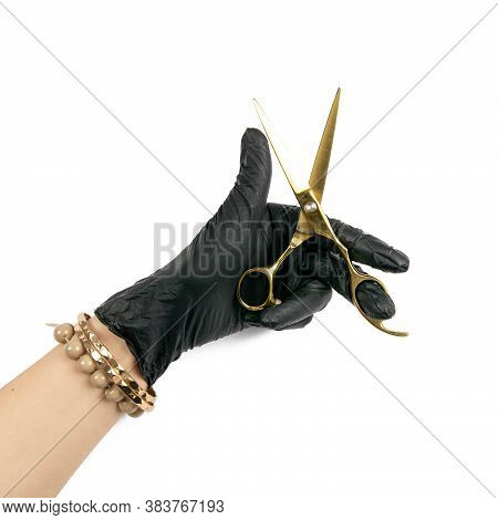 Gloved Hand Holding A Gold Scisors On An Isolated White Background.