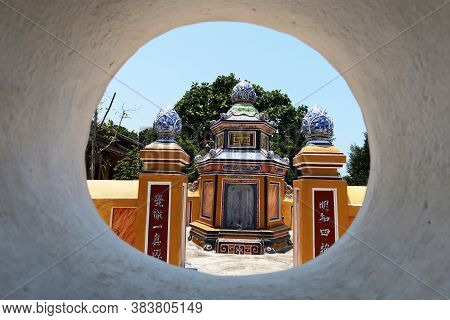 Hoi An, Vietnam, May 3, 2020: Mausoleum Seen Through A Wall In The Cemetery Of The Chùa Phước Lâm Te