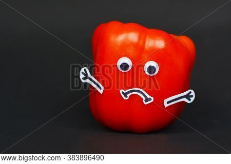 Creative Food Photography Of Red Ripe Bell Pepper With Funny Goggle Eyes, Stick Hands And Sad Mouth 
