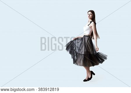 Young Beautiful Brunette Girl In Waving Dark Box Pleated Midi Skirt Posing In Studio. Woman Dancing 