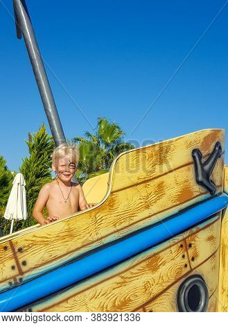 Pirate Day. A Little Boy Looking Like A Pirate With A Parrot Is Standing On A Sinking Ship In The Po