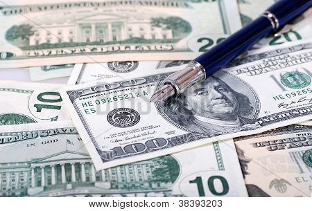 ปากกาหรูสีน้ำเงินบนพื้นหลังดอลลาร์