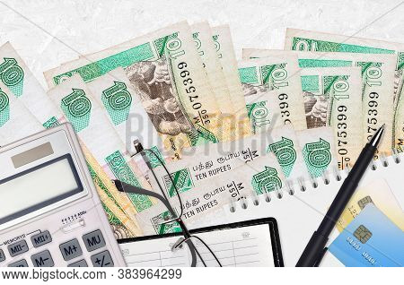 10 Sri Lankan Rupees Bills And Calculator With Glasses And Pen. Tax Payment Concept Or Investment So