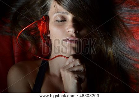 Красивая молодая женщина с красной Наушники