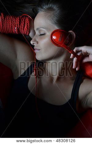 Красивая молодая женщина с красной Наушники