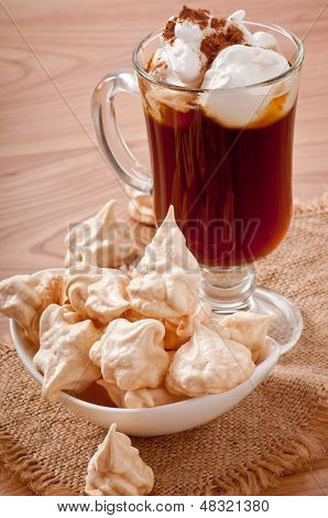 เมอแรงครีมขาวบนจานและกาแฟ