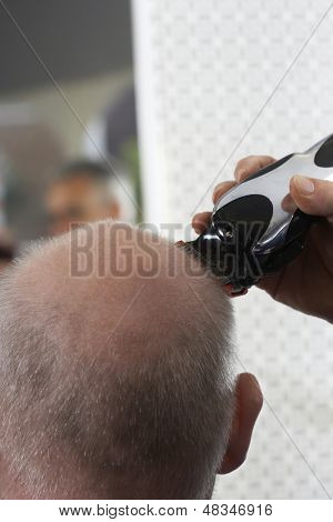 Kuaför berber dükkanı olarak saç düzeltici ile üst düzey adamın başını tıraş