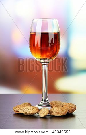 Sklenice likéru amaretto a pražených mandlí, na světlé pozadí