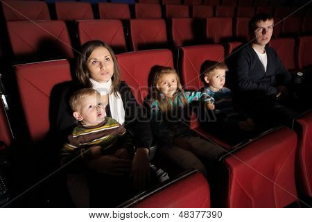 Forældre med deres børn ser en film i biografen 