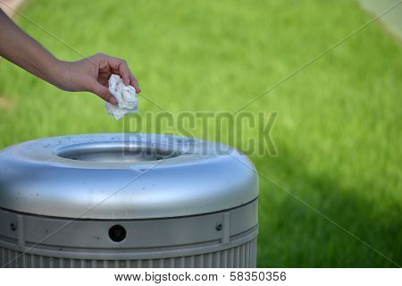 Hand throwing a paper in the trash