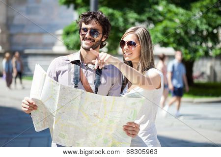 Couple of young tourists reading a map
