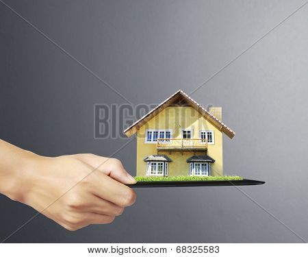 house on ,touch- tablet in a hands 