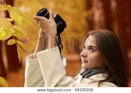 girl with camera in autumn forest