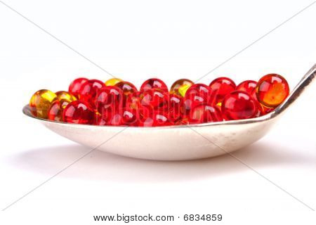 Beyaz izole kırmızı ve sarı kapsül kaşıkla