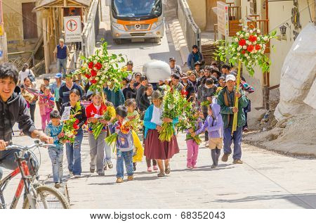 PERU, OLLANTAYTAMBO, MAY 4, 2014 -  Funeral procession of people carrying a white coffin and bunches of flowers heads to local cemetery