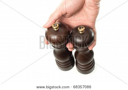 Asian Male Hand Holding Wooden Salt And Pepper Shakers On White Background
