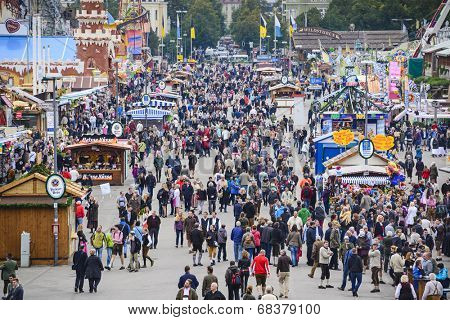 MUNICH, GERMANY - SEPTEMBER 30, 2013: Visitors explore the Theresienwiese Oktoberfest fair grounds. The 16 day festival has been annually celebrating beer since 1810.