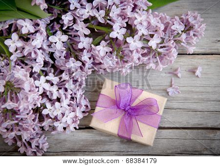 Gift Box With Purple Bow And Lilac On Wood