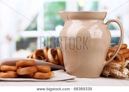 jar of milk, tasty bagels and spikelets on table