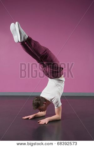 Cool break dancer doing handstand in the dance studio