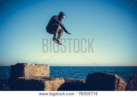 man performs freerunning jump on stones